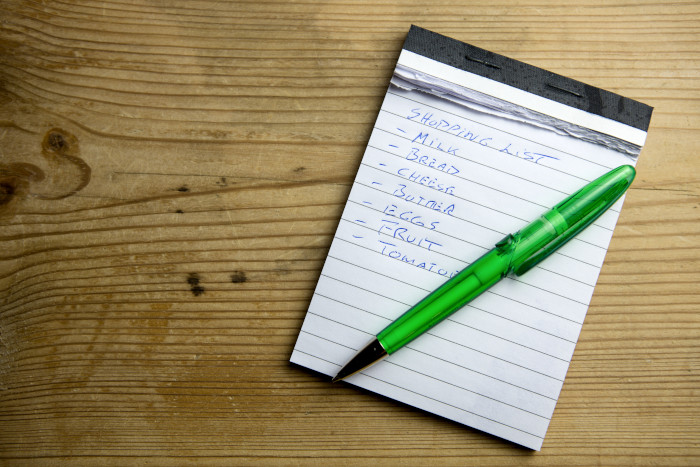 Shopping list on paper, with a pen